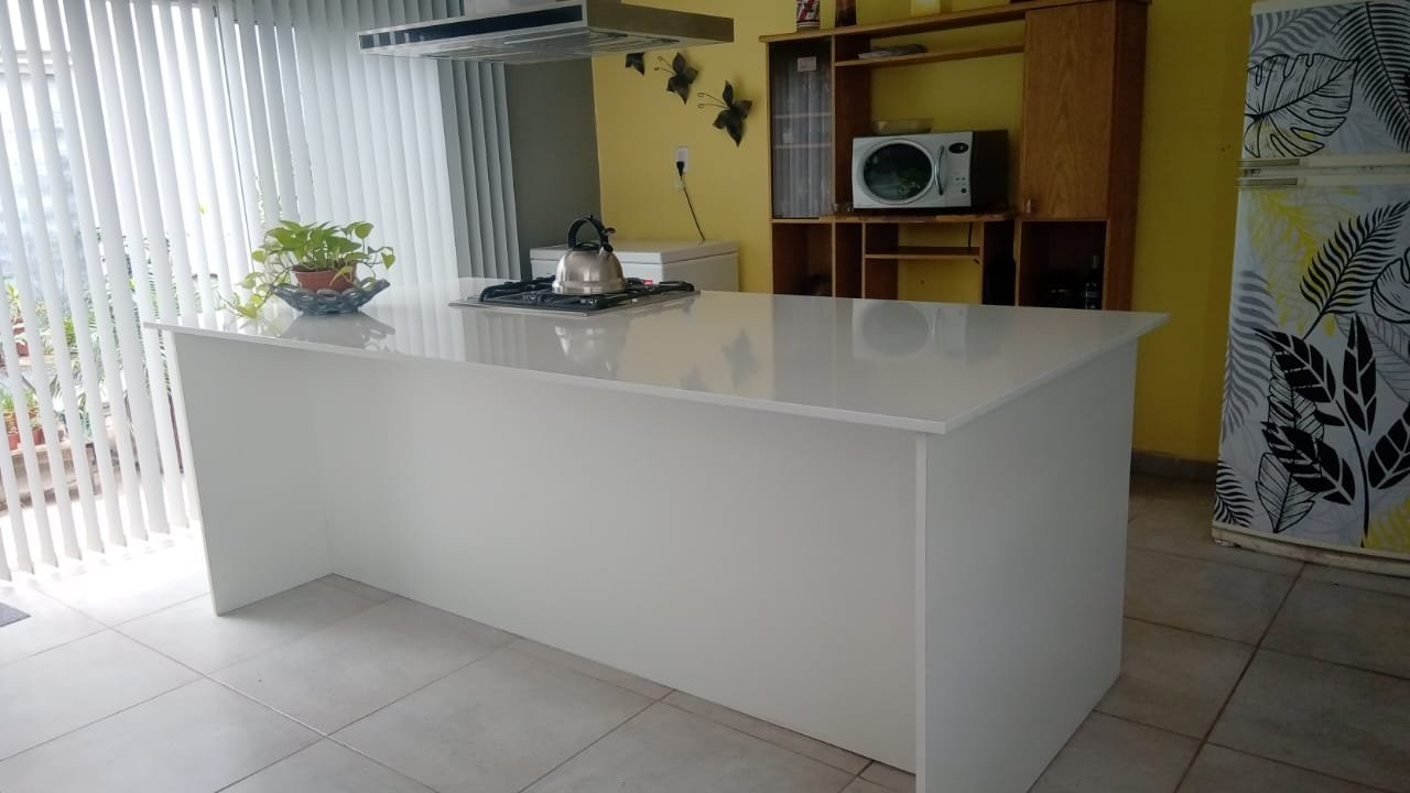 Isla de cocina con mesada blanca de cuarzo